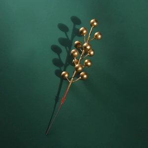 Golden artificial Christmas berry stem ornament on dark green background