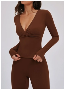 Detail of coffee brown V-neck yoga top with thumbhole sleeves and matte athletic fabric