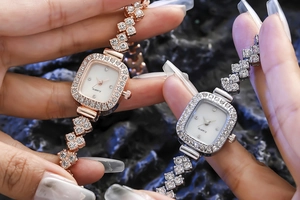 Gros plan de montres à quartz carrées or rose et argent avec cristaux de strass