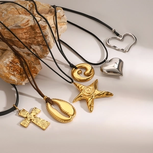 Starfish and cross pendant necklaces with gold metal charms on black cord cords
