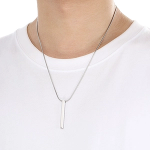 Close-up of a silver rectangular bar pendant on a sleek snake chain worn by a model