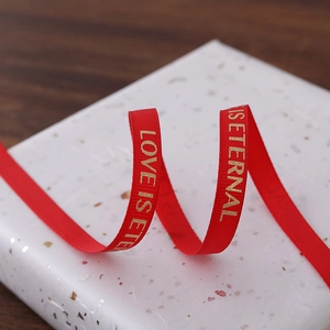 Red silk ribbon with gold LOVE IS ETERNAL lettering for gift wrapping and floral decoration