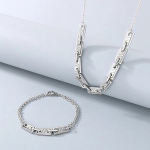 Macro view of silver stainless steel necklace and bracelet set with textured rectangular links