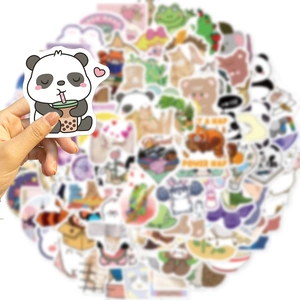 Close-up of hand holding a cute panda waterproof sticker for DIY laptop decoration
