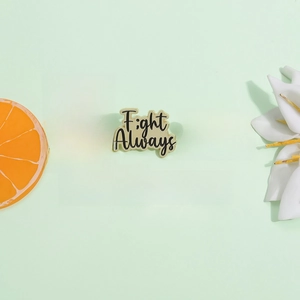 Five gold enamel pins for mental health awareness on a green background with flowers