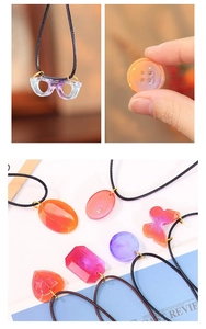 Détail de pendentifs colorés en résine avec paillettes, diverses formes et cordons tissés