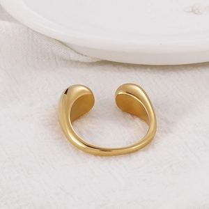 Detailed macro shot of a gold-plated stainless steel open ring with teardrop ends