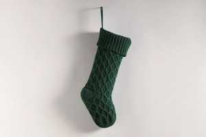 Nahaufnahme einer dunkelgrünen Strick-Weihnachtssocke mit klassischem Rautenmuster