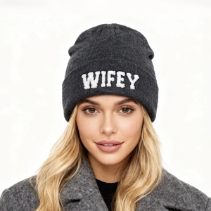 Détail du bonnet gris en maille avec broderie blanche WIFEY porté par un mannequin