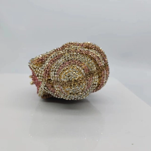 Detailed close-up of seashell shaped stone clutch bag with pink and gold crystals