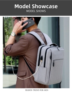 Detail of grey business backpack showing side USB charging port connected to a phone
