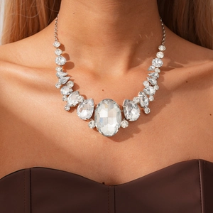 Close-up of elegant rhinestone teardrop and oval necklace set on a model collarbone
