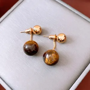 Vintage 18k gold plated tiger eye stone drop earrings on grey jewelry box