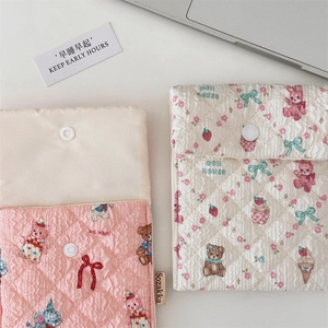 Nahaufnahme gesteppter Stofftaschen mit niedlichen Bären- und Katzenprints und Druckknopf