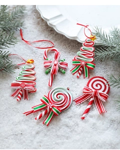 Macro detail of red and white striped candy cane ornaments on festive snowy background