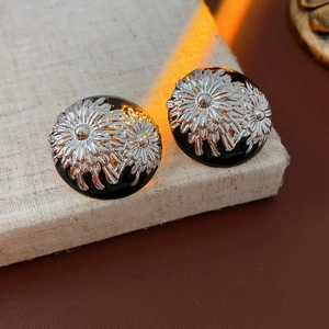 Macro detail of vintage floral silver earrings with black enamel and sunflower motifs