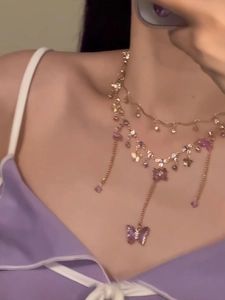 Close-up of double-layer gold chain necklace with purple butterfly fringe pendants