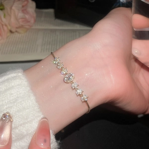 Close-up of gold plated flower bracelet with marquise-cut cubic zirconia and slide clasp