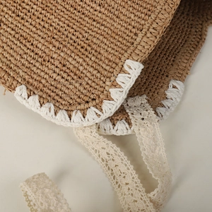 Handmade raffia straw hat with white crochet lace trim and delicate ribbon ties