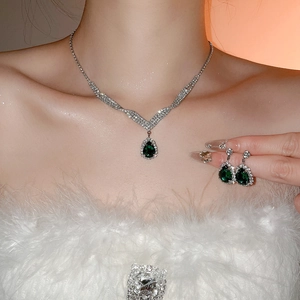 Elegant silver necklace and teardrop green gemstone earrings worn by model
