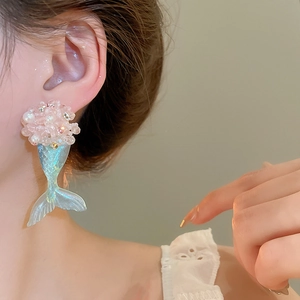 Detail of flower-shaped earring with pink beads and a translucent mermaid tail pendant