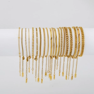 Detail of 18K gold plated stainless steel chain bracelets with various links on a stand