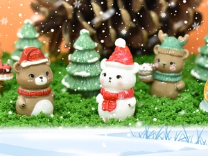 Detailed macro view of resin Christmas bear and tree figurines in a festive snowy scene