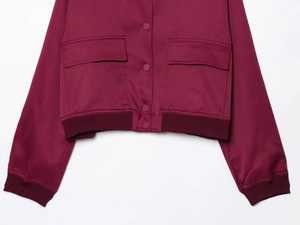 Detail of wine red utility jacket featuring snap buttons and large flap pockets