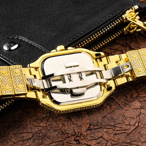 Detail of the golden iced-out watch showing the secure metal butterfly clasp mechanism