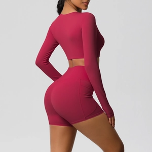 Zijaanzicht van de diep bessenrode yogaset met hoge taille shorts en zijzakken