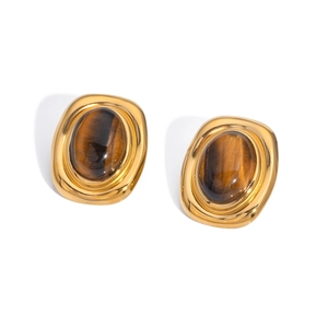 Detailed macro view of vintage gold steel stud earrings with oval tiger eye stones