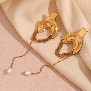 Detail view of gold fringe drop earrings with elegant white pearls and layered chains