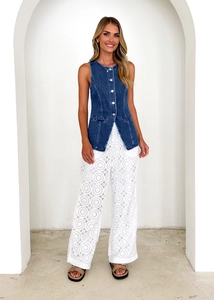 Detail of dark blue denim button vest paired with white lace hollow wide-leg pants