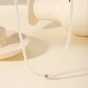 Detailed shot of white pearl necklace with gold diamond pendant in an elegant setting