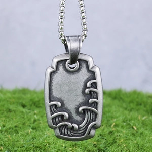 Vue détaillée du pendentif vintage en acier avec totem de vagues et texture en relief