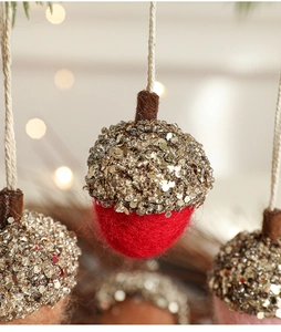 Macro shot of red wool felt Christmas acorn ornament with golden glitter and beads