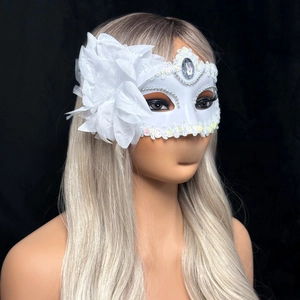 Detail of white masquerade mask with large fabric flower, lace trim and rhinestones