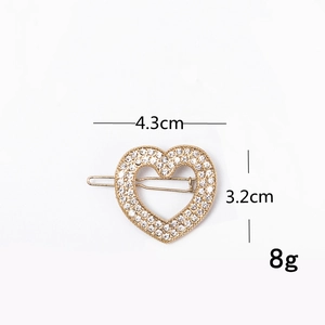 Macro shot of rhinestone heart hair clip showing dimensions 4.3cm by 3.2cm and 8g weight