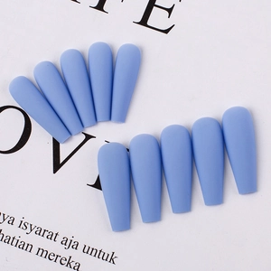 Detailed view of matte blue coffin press-on nails with smooth frosted texture on white paper