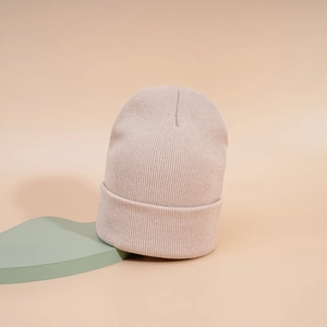 Texture de tricot détaillée du bonnet rose clair avec anneaux de fer sur accessoires