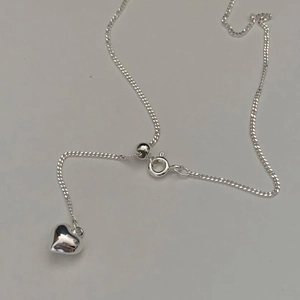 Adjustable minimalist 925 sterling silver heart necklace with polished finish on gray background