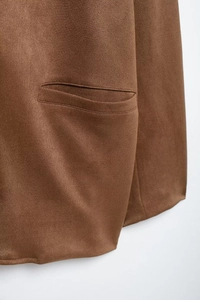Detailed close-up of welt pocket on brown faux suede warm blazer with fine stitching