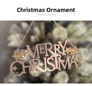 Close-up of wooden Merry Christmas sign with gold glitter stars on a festive tree