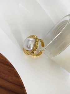 Detailed macro shot of vintage pearl ring with golden wheat textured setting