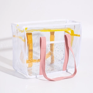 Detail of transparent PVC beach bag with white mesh sides and pink handles