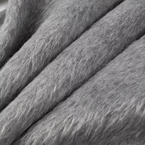 Close-up of soft grey plush faux fur fabric showing high-quality fuzzy texture detail