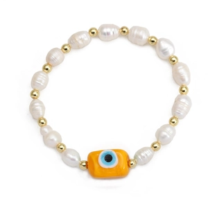 Macro detail of natural freshwater pearls and orange evil eye charm on a gold-beaded bracelet