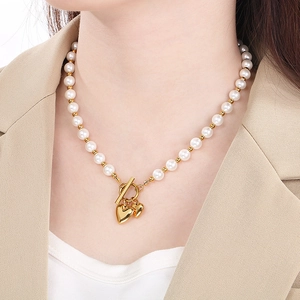 Detail of gold titanium heart pendant necklace with pearls and OT toggle closure