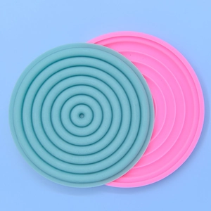 Blue and pink silicone cake molds with concentric circle texture on blue background