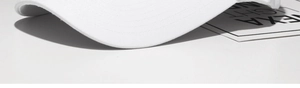 Macro shot of fine stitching on the long brim of a white cotton baseball cap
